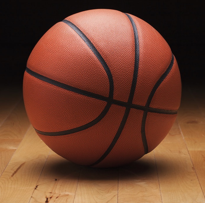An orange basketball resting on an outdoor court